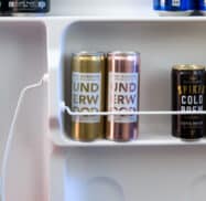 A refrigerator door shelf with various canned beverages, including Underwood wines, a spiked cold brew coffee, and a Bud Light.